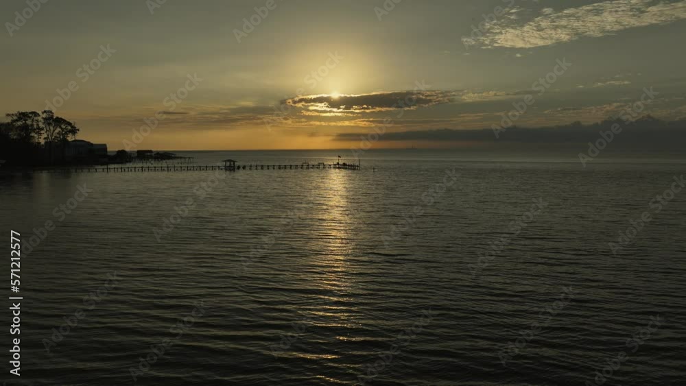 Disappearing sun behind clouds over Mobile Bay, Alabama aerial reverse reveal Disappearing sun behind clouds over Mobile Bay, Alabama aerial reverse reveal