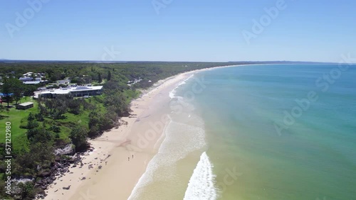 Tourists On Vibrant Sand Dunes With Blue Sea Water In Rainbow Beach, Cooloola, Australia. aerial pullback photo
