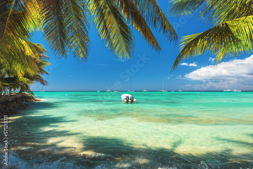 Fotografia Tropical beach, palm tree and speed travel boat in Punta Cana, Dominican Republi