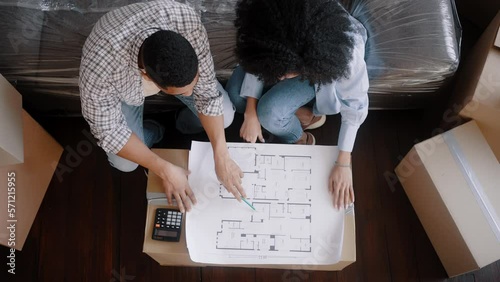 Top view multi-ethnic couple calculating materials for home renovation and interior decoration