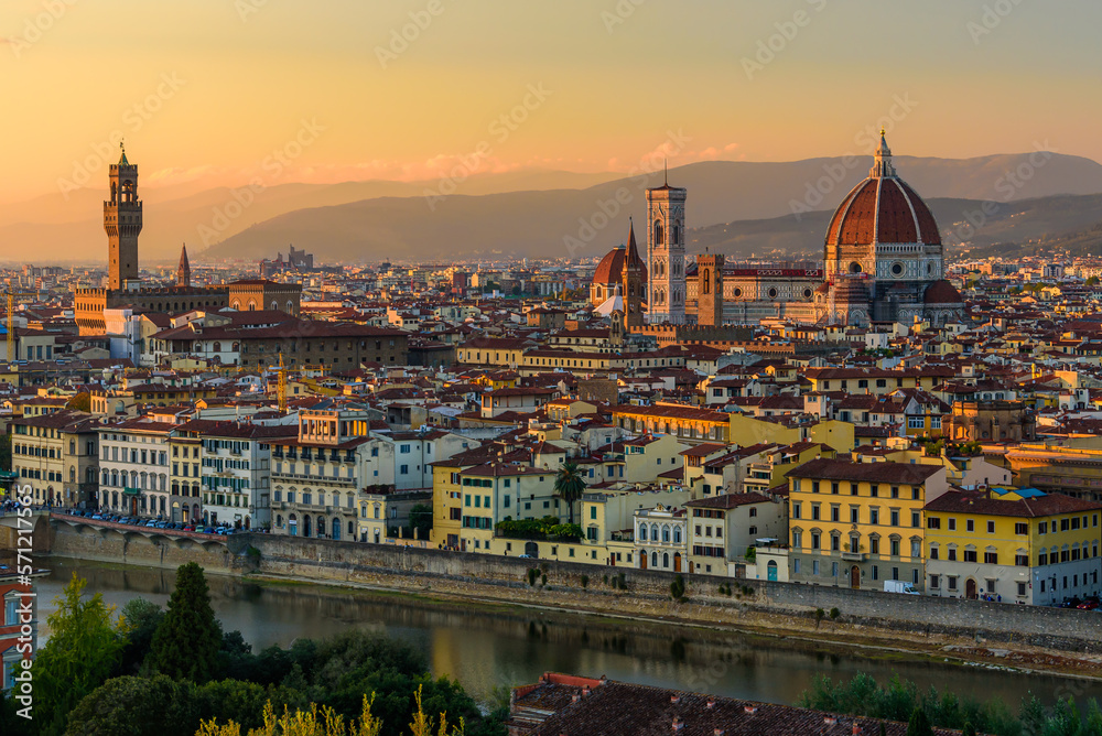 The Florence cityscape with the Florence Cathedral and Palazzo Vecchio in an orange sunset.