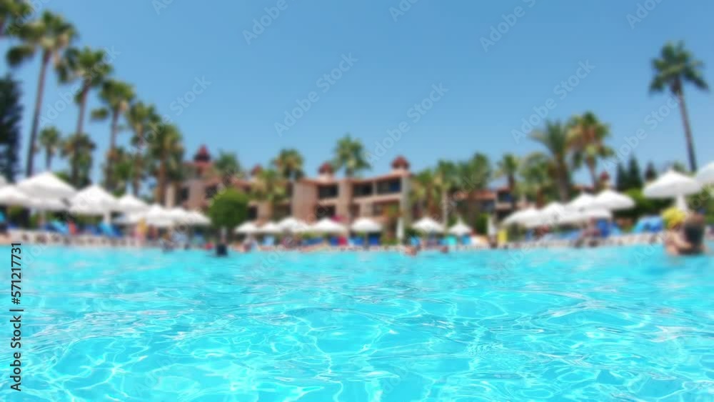 View of the beautiful pool with turquoise water. The concept of summer holidays in the resort. Against the backdrop of palm trees and people who are resting at the resort. View of the beautiful pool with turquoise water. The concept of summer holidays in the resort. Against the backdrop of palm trees and people who are resting at the resort.