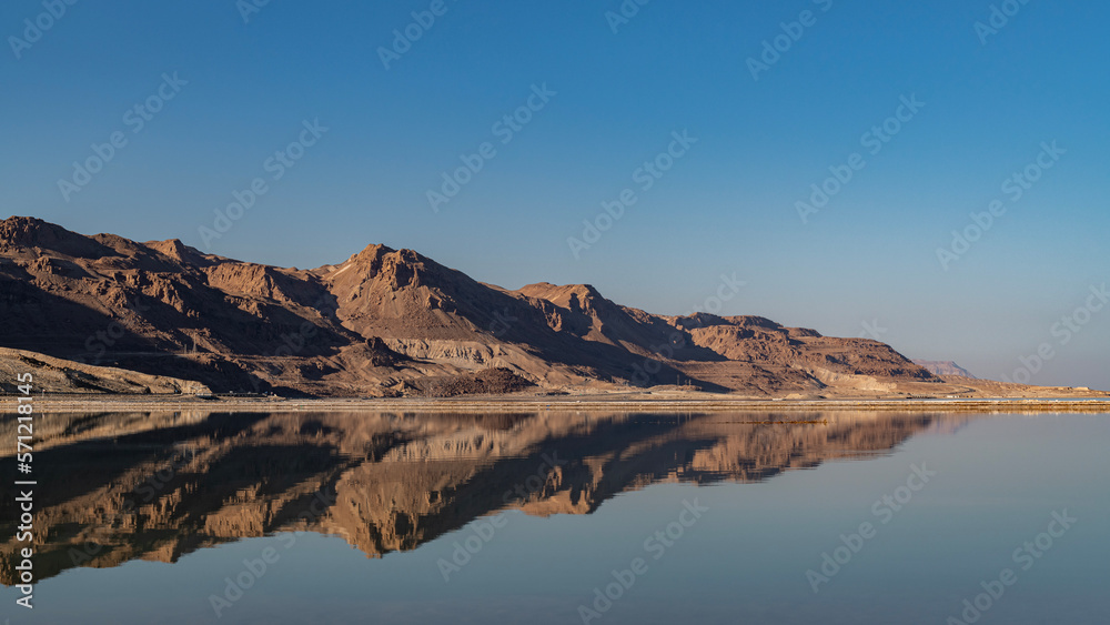 The beautiful Judean desert mountains reflected in the Dead Sea at Ein Bokek, Israel.
