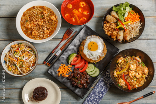 Composition des plats asiatique dans une vaisselle colorée, servie sur fond rustique bleu, vue de dessus. Ensemble de cuisine chinoise, vietnamienne, thaïlandaise. 