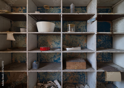 Bowls and other unique items on a shelf in an abandoned hospital