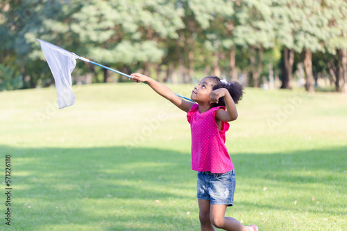 Cute little kid girl playing outdoors in the garden, Black child girl in the park