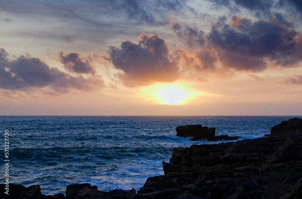 Scenic landscape view of dramatic sunset sky at rocky shore of the Atlantic ocean near Cascais, Portugal Scenic landscape view of dramatic sunset sky at rocky shore of the Atlantic ocean near Cascais, Portugal