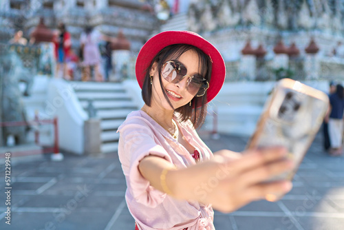 Photography happy thai woman taking seflie at wat arun temple in bangkok thailand