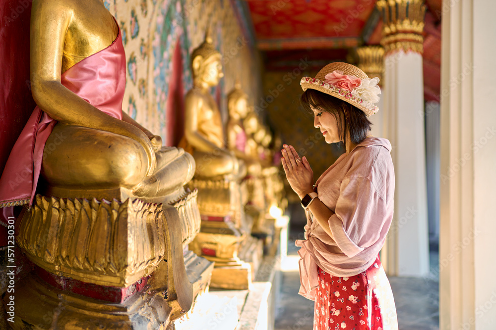 Obraz premium thai woman praying and making wai at wat arun temple in bangkok thailand