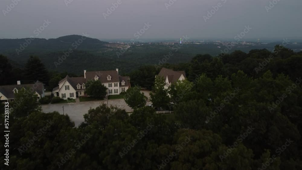 Aerial flight over trees revealing houses in Branson, MO.
