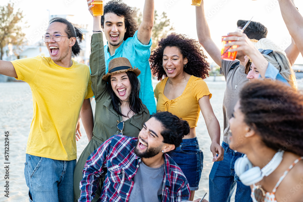 Friends having a beach party, young people having fun dancing and drinking on holiday, happy girls and boys at music festival