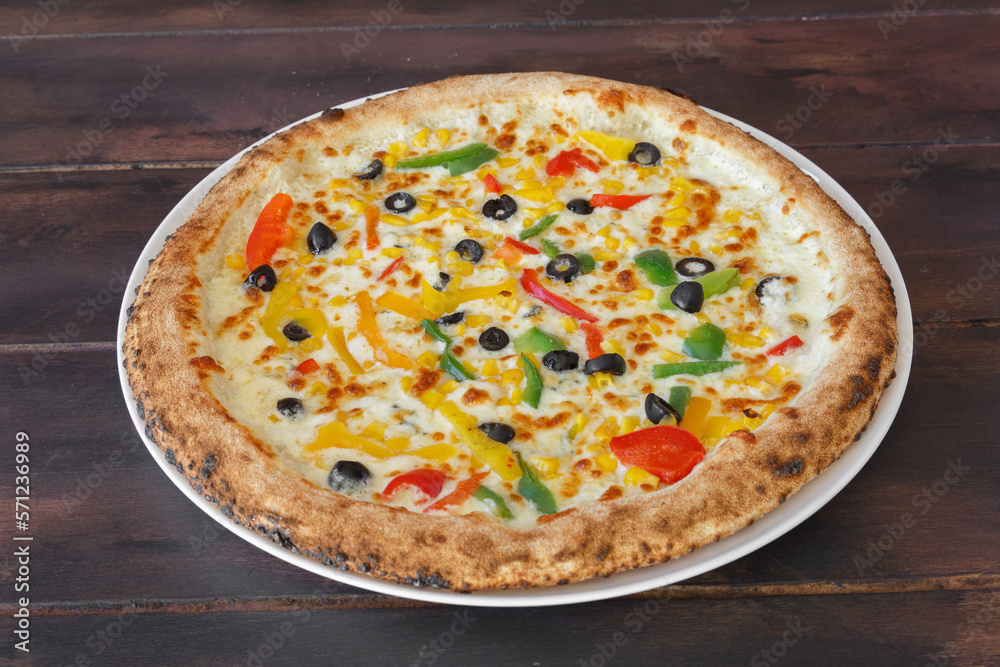 Pizza orientale épicée fait maison dans une assiette sur une table en bois. Gros plan. Pizza orientale épicée fait maison dans une assiette sur une table en bois. Gros plan.