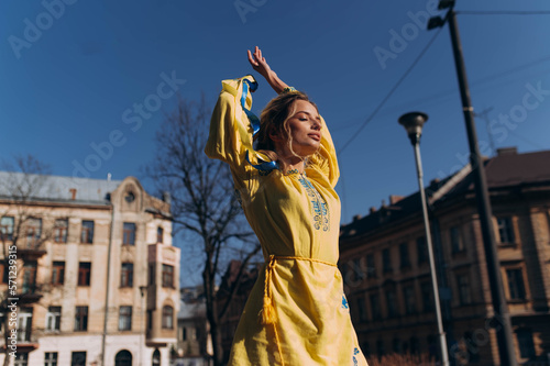 a girl in a yellow Ukrainian dress walks down the street on a sunny day. Independence Day of Ukraine