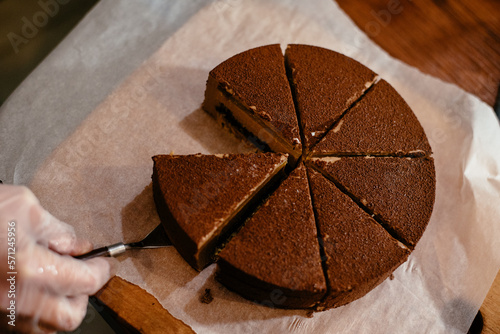 A Caucasian woman is cutting a chocolate cake. Delicious chocolate cake with orange. Homemade baking