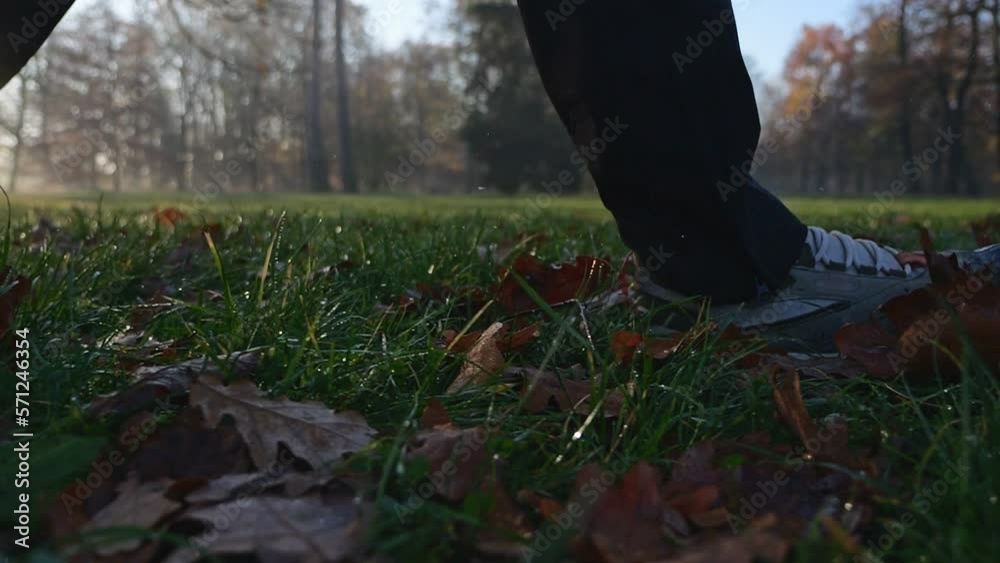 Close-up of shoes spreading autumn leaves in the park. Recorded in slow motion Close-up of shoes spreading autumn leaves in the park. Recorded in slow motion