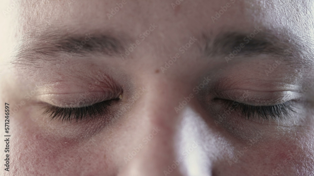 Obraz premium Person closing eyes in meditation and opening looking at camera. Macro close up of calm man eye in contemplation