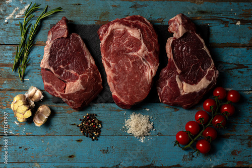 Variety of Raw Black Angus Prime meat steaks Machete, Blade on bone, Striploin, Rib eye, Tenderloin fillet mignon on wooden board copy space. High quality photo