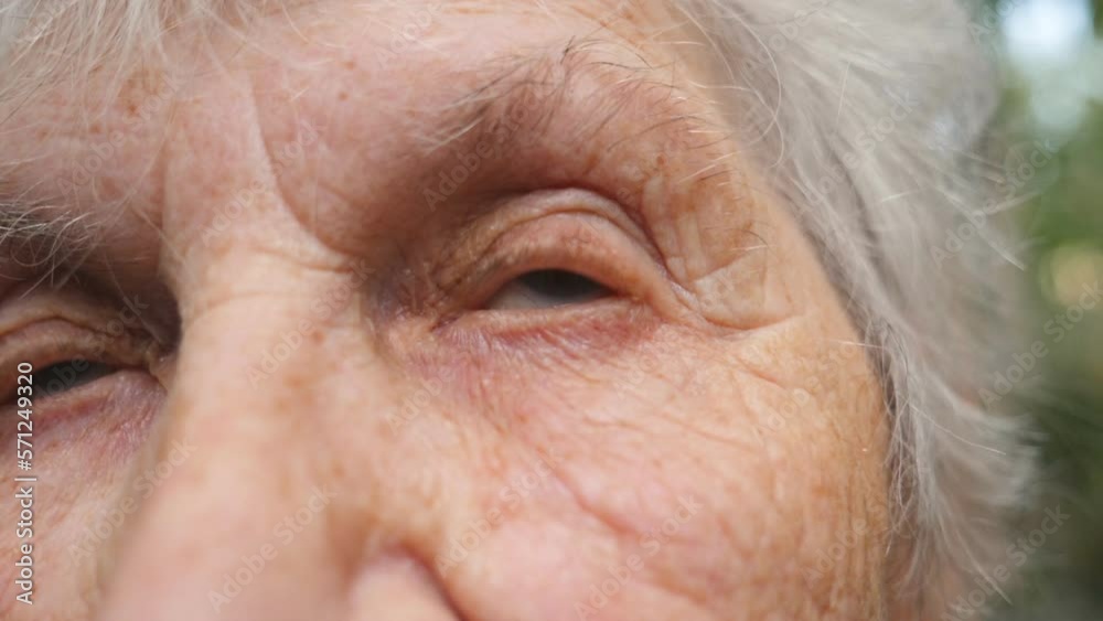 Portrait of old grandmother looking up. Close up eyes of an elderly woman with wrinkles around them Portrait of old grandmother looking up. Close up eyes of an elderly woman with wrinkles around them