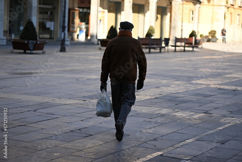 An elderly man carries his groceries home in Leon-Spain.