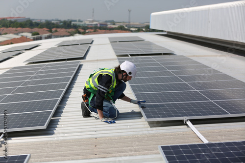 Maintenance engineer, Solar energy systems engineer perform analysis solar panels, Engineer service check installation solar cell on the roof of factory.  photo