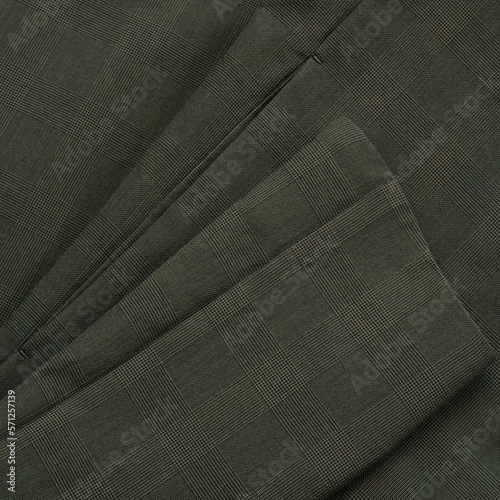 Detail of a checkered dark green jacket with a sleeve and a pocket