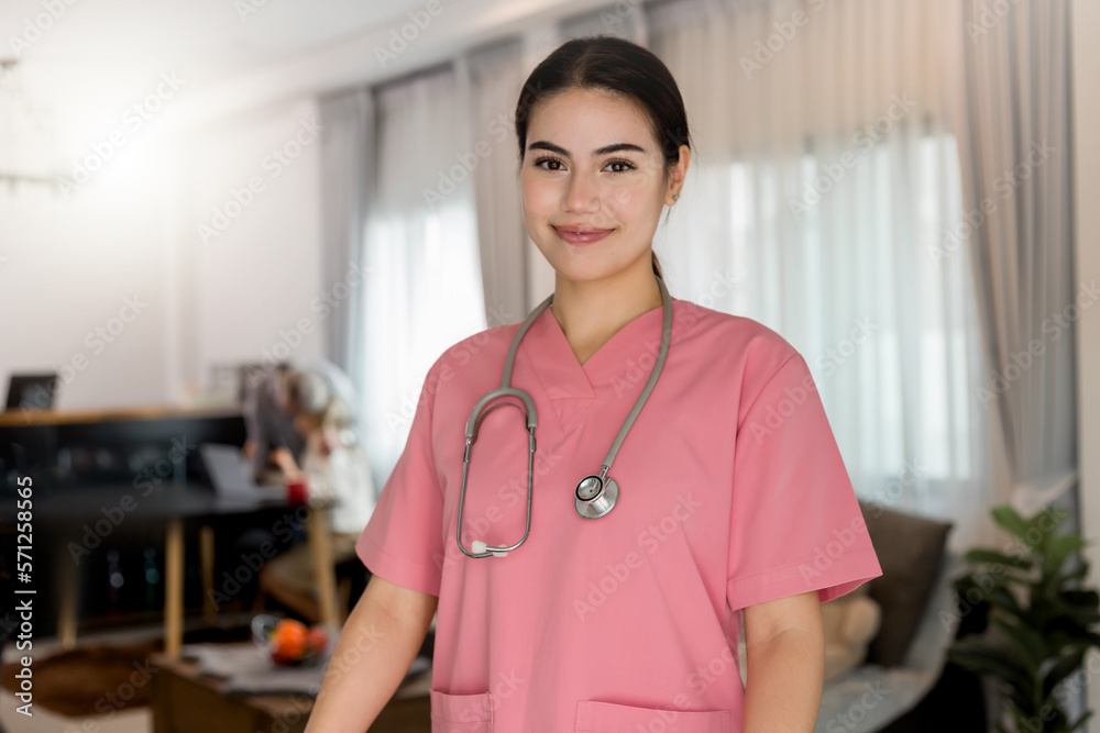 Young processional Caucasian Geriatric doctor in pink scrubs with stethoscope roll wheelchair. Physician in hospital nursing home or wellbeing county. Happy caregiver taking care of elderly people.