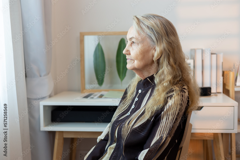 Side view of sad thoughtful middle-aged mature woman sit on couch at home look in window distance mourning, upset pensive senior female lost in thoughts thinking or pondering over past Side view of sad thoughtful middle-aged mature woman sit on couch at home look in window distance mourning, upset pensive senior female lost in thoughts thinking or pondering over past