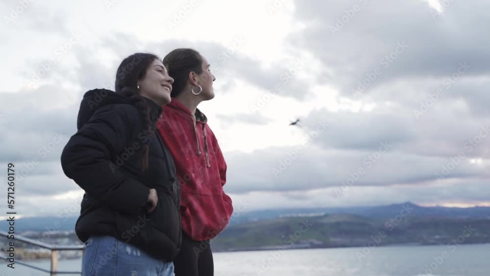 lesbian couple of two scorched women talking and enjoying the sunset on the sea shore, lgbt lesbian couple of two scorched women talking and enjoying the sunset on the sea shore, lgbt