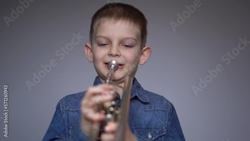 Young boy shows joy and love for his trumpet. Beloved musical instrument