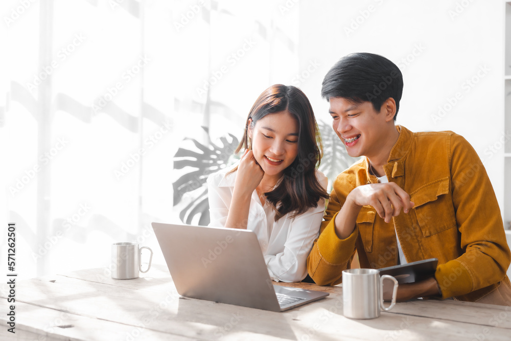 Asian couple husband and wife using laptop and paper bills at home use banking applications sit together at the table A cautious family spouse is confused by high expenses. insurance or rent concept Asian couple husband and wife using laptop and paper bills at home use banking applications sit together at the table A cautious family spouse is confused by high expenses. insurance or rent concept