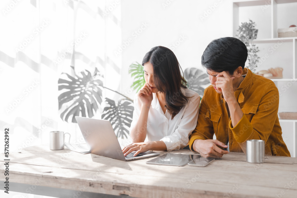 Fails, Stressed Asia couple husband and wife using laptop and paper bills at home use banking applications sit together at the table A cautious family spouse is confused by high expenses.