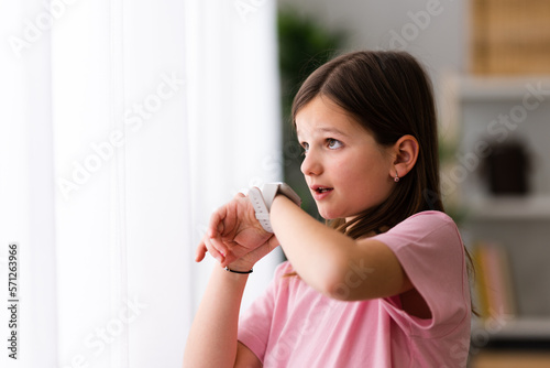 Little girl talking on smartwatch