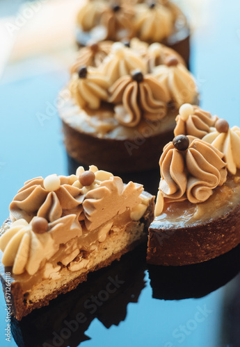 Shortbread tartlets with salted caramel and nuts. Sweet chocolate cakes. Modern mini desserts for candy bars, parties. Selective focus photo