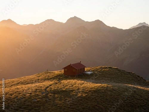 Sunset panorama of red idyllic remote lonely alpine mountain Brewster Hut above Haast valley Southern Alps New Zealand photo