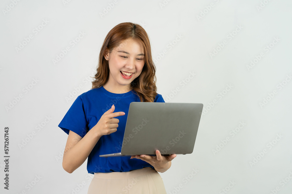Cute Asian teenage woman smiling happily excited excitedly working with computer on white background Cute Asian teenage woman smiling happily excited excitedly working with computer on white background