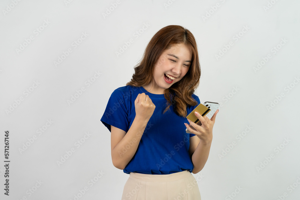 Attractive Asian woman in blue t-shirt using smartphone for internet banking business casual wear isolated with white background Attractive Asian woman in blue t-shirt using smartphone for internet banking business casual wear isolated with white background