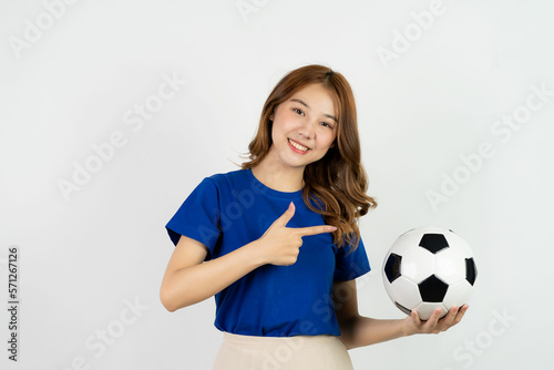 Happy Asian female soccer fan in blue shirt cheering for favorite team with soccer ball isolated on white background, pretty young pretty girl holding soccer ball, sports concept © ArLawKa
