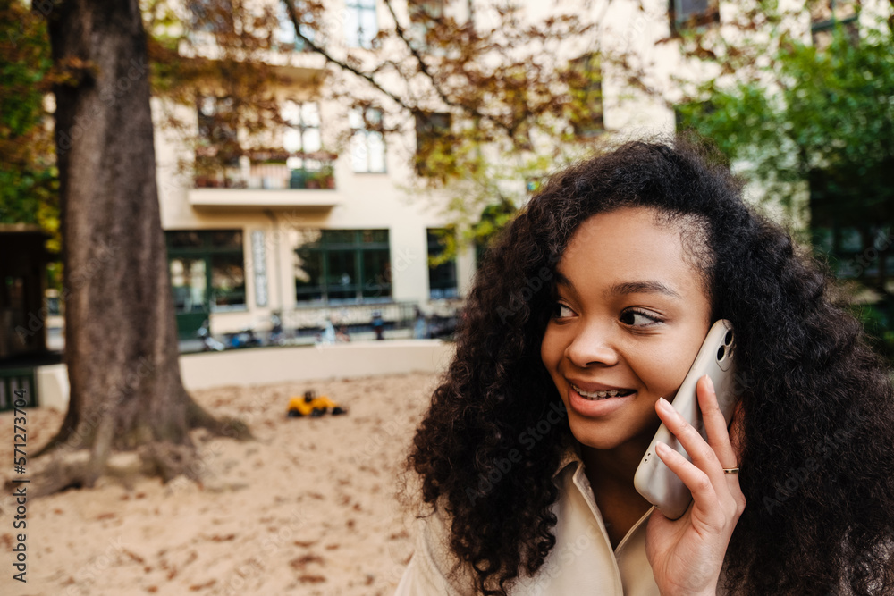 African american woman talking on cellphone while walking outdoors