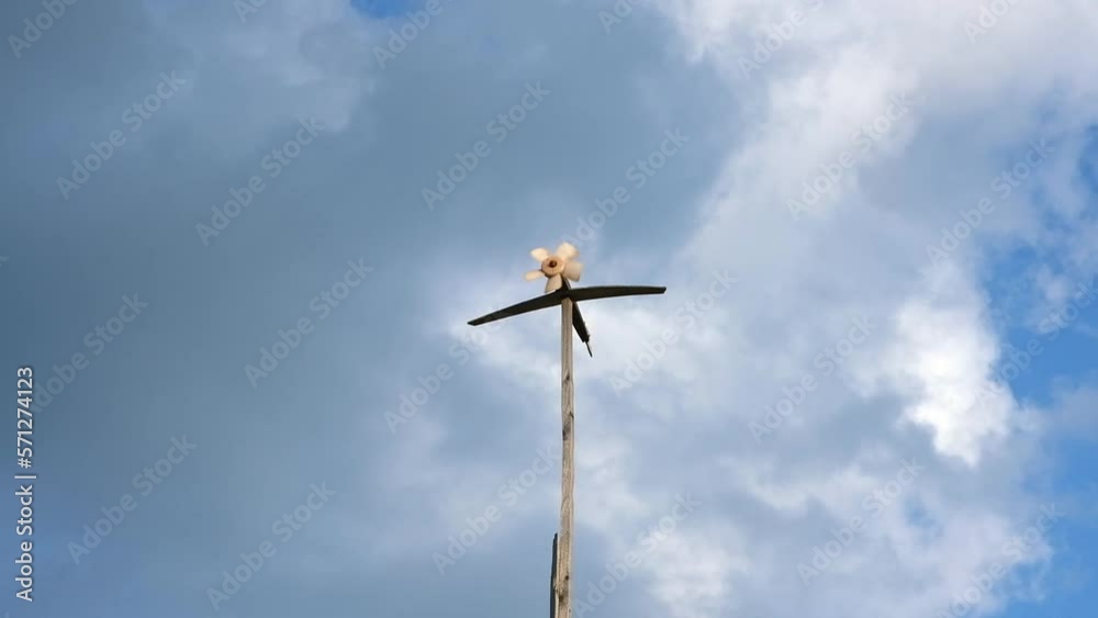 A homemade weather vane turns and shows the strength and direction of the wind. A weather vane