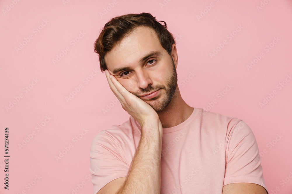 Bored man propping his head isolated over pink background Bored man propping his head isolated over pink background
