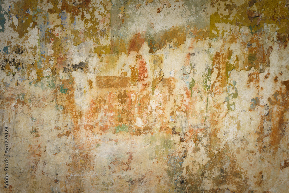 Detail of old wall in warm tones with a lot of texture and remains of paint.
