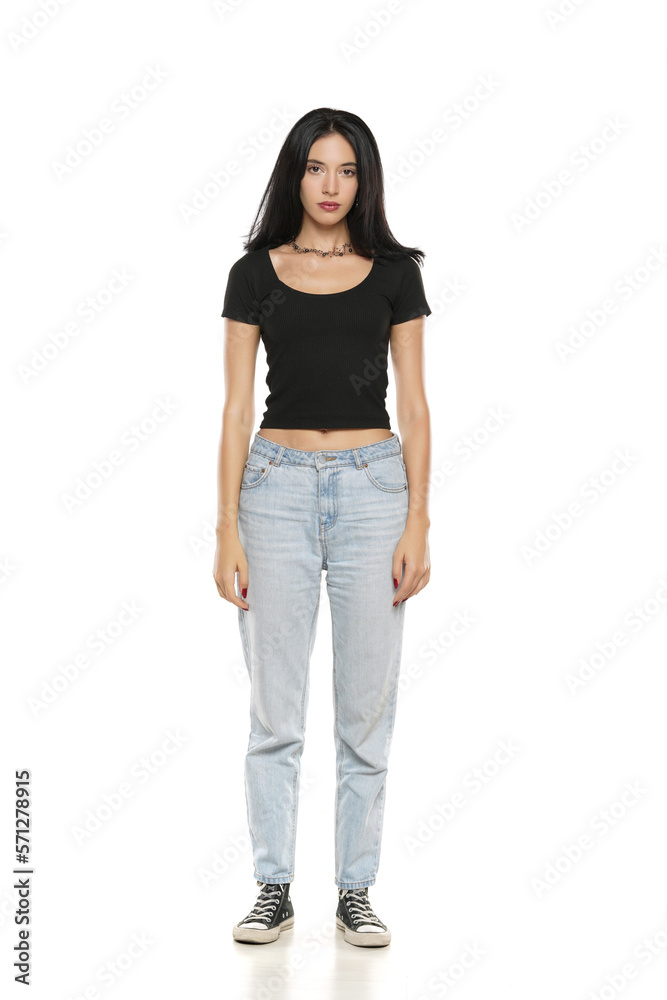 Young beautiful woman in loose jeans posing on white background Young beautiful woman in loose jeans posing on white background