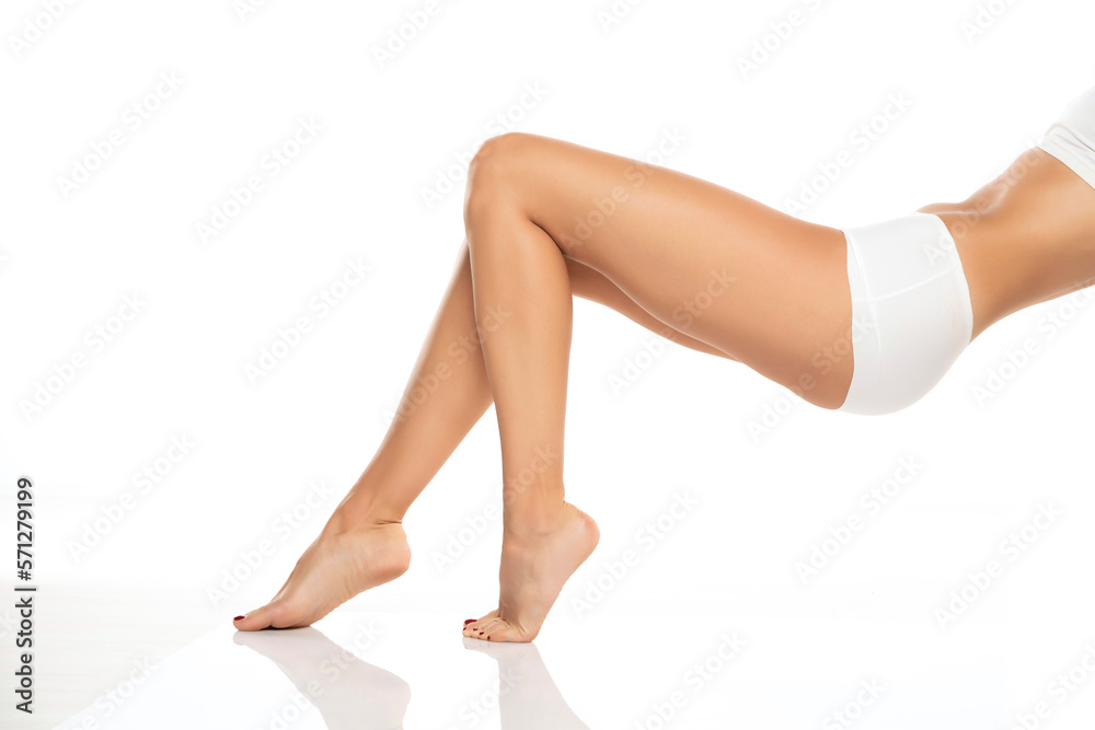 Side view of beautifully cared women's legs and feet on white background.