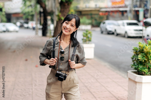 Young Asian woman backpack traveler enjoying street cultural local place and smile. Traveler checking out side streets.  © Jirawatfoto