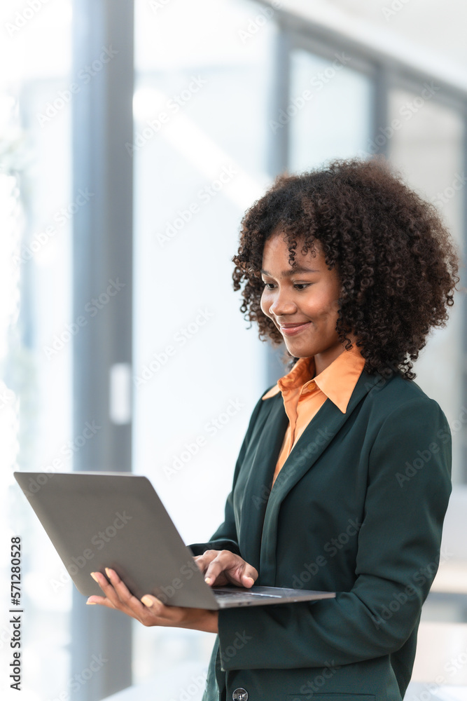 Using laptop computer, Young pretty african american business woman bookkeepers working with balance sheet yearly reports to calculate tax and online consult in modern office. Using laptop computer, Young pretty african american business woman bookkeepers working with balance sheet yearly reports to calculate tax and online consult in modern office.