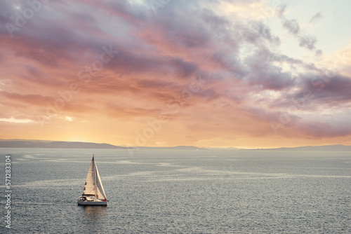 Sunset Seascape with white yacht sailing the sea