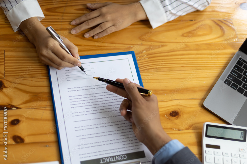 Signing a business contract agreement. Businessmen discuss and explain the details of the terms of the contract, a legal agreement. Signing a business contract agreement. Businessmen discuss and explain the details of the terms of the contract, a legal agreement.