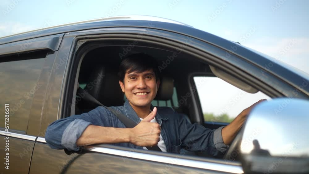 Surprised young handsome man thumbs up in getting the new car. He hugged his a car as a gift from his savings and was feeling proud and very happy. Buy or rent car concept. Surprised young handsome man thumbs up in getting the new car. He hugged his a car as a gift from his savings and was feeling proud and very happy. Buy or rent car concept.