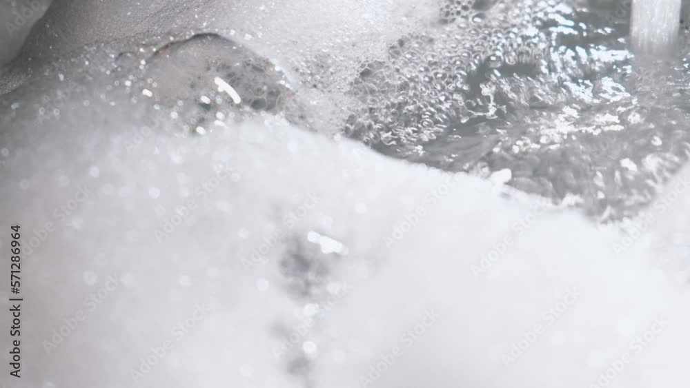 Foam floats on the surface of the water in the bathroom, close-up Foam floats on the surface of the water in the bathroom, close-up