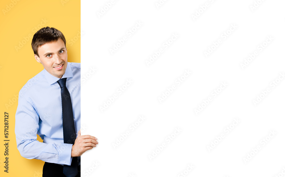 Portrait image of business man professional bank manager in confident cloth, necktie stand behind show empty white banner signboard billboard with copy space area. Isolated on orange yellow background Portrait image of business man professional bank manager in confident cloth, necktie stand behind show empty white banner signboard billboard with copy space area. Isolated on orange yellow background